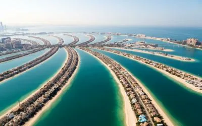 Aerial view of the Palm Jumeirah man-made islands extending into the clear blue sea, representing the Jumeirah and JBR coastline. Local movers serving Jumeirah and JBR by dxbmovershub.com.